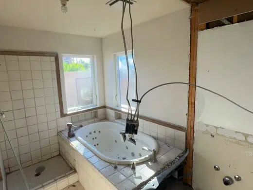 Bathroom remodel plumbing work with walls and fixtures exposed for Plumbing Services in Bellflower, CA
