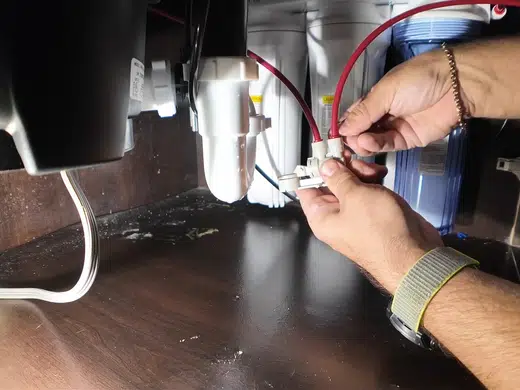 Garbage disposal unit and drain connections under a kitchen sink for Plumbing Services in Bellflower, CA